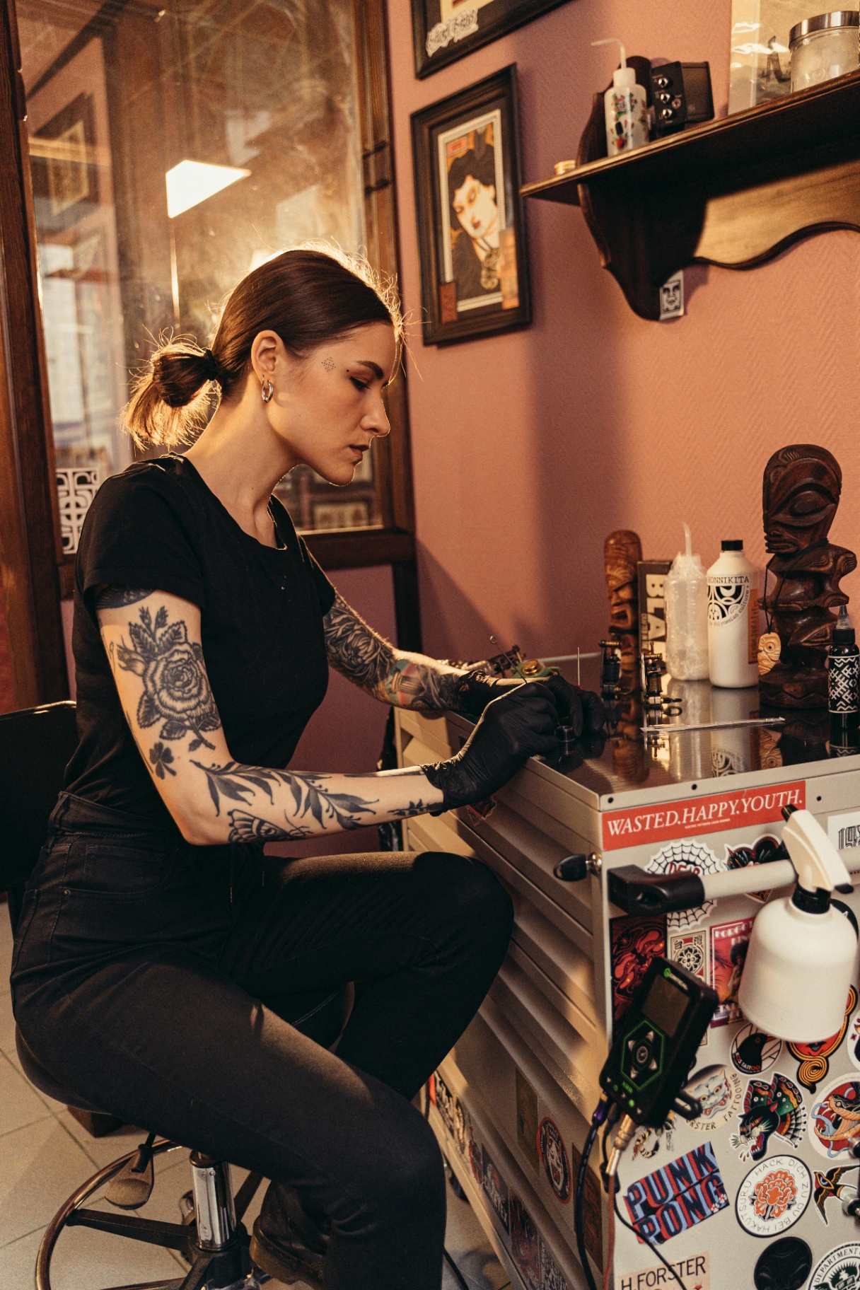 Vyx Kade, tattoo artist, in a neon-lit Berlin studio